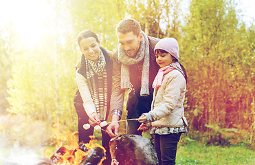 Image showing happy family roasting marshmallow over campfire