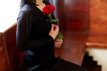 Image showing close up of woman with roses at funeral in church