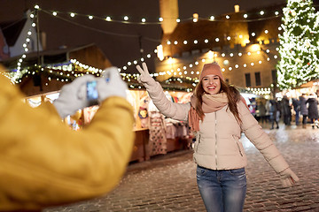 Image showing happy woman posing for smartphone at christmas