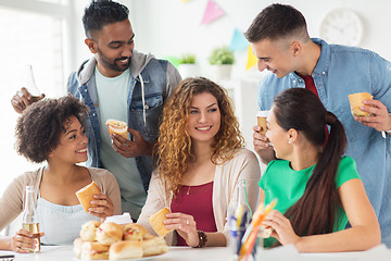 Image showing happy friends or team eating at office party