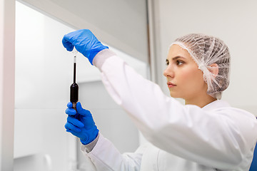 Image showing woman with sulphuric acid in dropper at laboratory