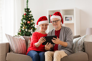 Image showing happy senior couple with tablet pc at christmas