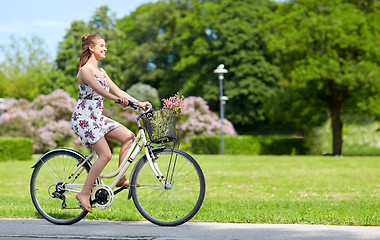 Image showing happy woman riding fixie bicycle in summer park