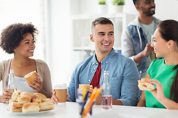 Image showing happy friends or team eating at office party