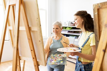 Image showing women with easels and palettes at art school