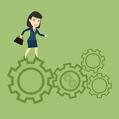 Image showing Business woman running on cogwheels.