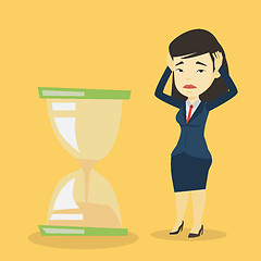 Image showing Desperate business woman looking at hourglass.