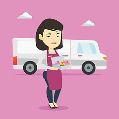 Image showing Delivery woman holding a box of cakes.