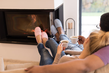 Image showing Young multiethnic couple  in front of fireplace