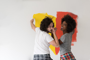 Image showing multiethnic couple painting interior wall