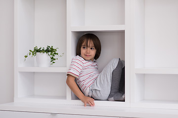 Image showing young boy posing on a shelf