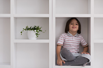 Image showing young boy posing on a shelf