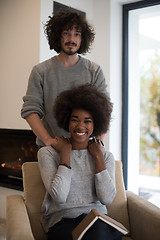 Image showing multiethnic couple hugging in front of fireplace