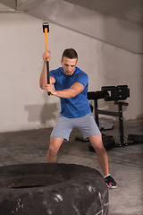 Image showing man workout with hammer and tractor tire