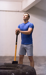 Image showing man workout with hammer and tractor tire