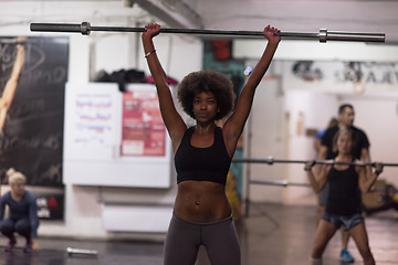 Image showing black woman lifting empty bar