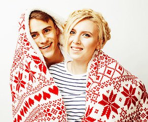 Image showing young pretty teenage couple at Christmas time warming in red decorated blanket, hipster guy with his girlfriend happy smiling and hugging isolated on white background, lifestyle people concept 