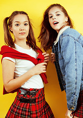 Image showing lifestyle people concept: two pretty young school teenage girls having fun happy smiling on yellow background