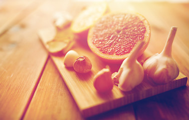Image showing garlic and grapefruit on wooden board