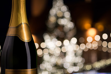 Image showing close up of champagne bottle over christmas lights