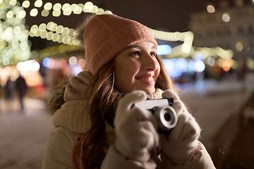 Image showing happy young woman with camera at christmas market