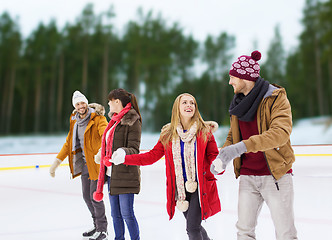 Image showing friends holding hands on outdoor skating rink