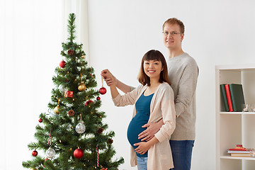 Image showing happy pregnant wife and husband at christmas tree