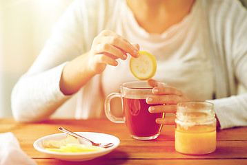 Image showing close up of ill woman drinking tea with lemon