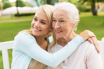 Image showing daughter with senior mother hugging on park bench