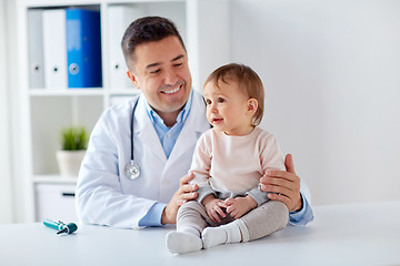 Image showing happy doctor or pediatrician with baby at clinic