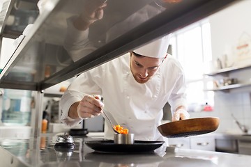 Image showing happy male chef cooking food at restaurant kitchen