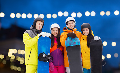 Image showing happy friends in helmets with snowboards