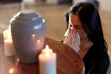 Image showing woman with cremation urn at funeral in church