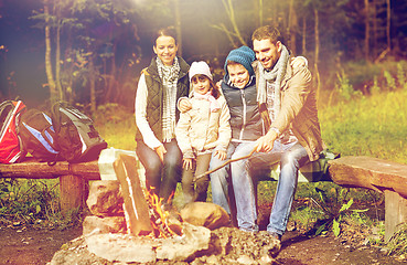 Image showing happy family sitting on bench at camp fire