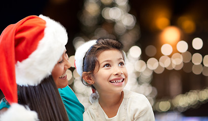 Image showing mother and daughter in santa hats at christmas