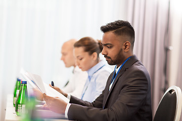 Image showing businessman with files at international conference