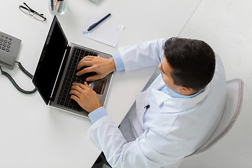 Image showing man doctor typing on laptop at clinic