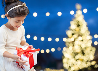 Image showing happy girl with gift box over christmas lights