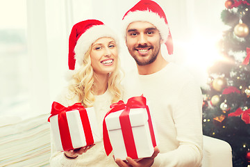 Image showing happy couple at home with christmas gift boxes