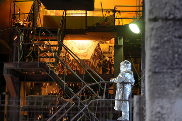 Image showing Molten Metal Pouring Out Of Furnace and Workers