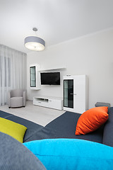 Image showing White living room with TV set, chair and grey sofa