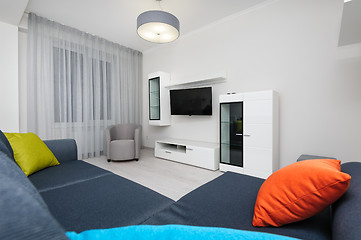 Image showing White living room with TV set, chair and grey sofa