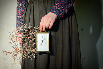 Image showing Girl with vintage dress holding clock