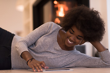 Image showing black women using tablet computer on the floor