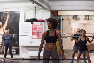 Image showing black woman lifting empty bar