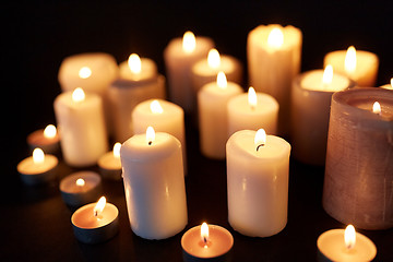 Image showing candles burning in darkness over black background