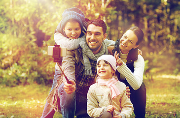 Image showing happy family with smartphone selfie stick in woods