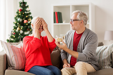 Image showing happy smiling senior couple with christmas gift