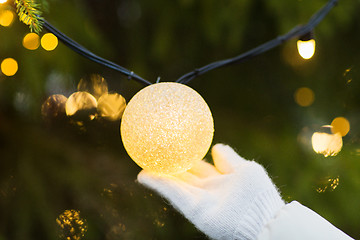 Image showing close up of hand with christmas tree garland bulb