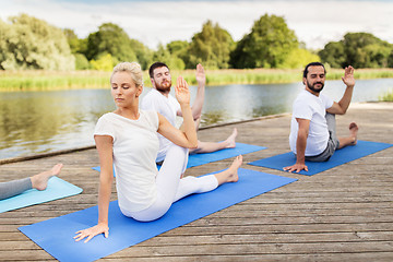 Image showing people making yoga in half lord of the fishes pose